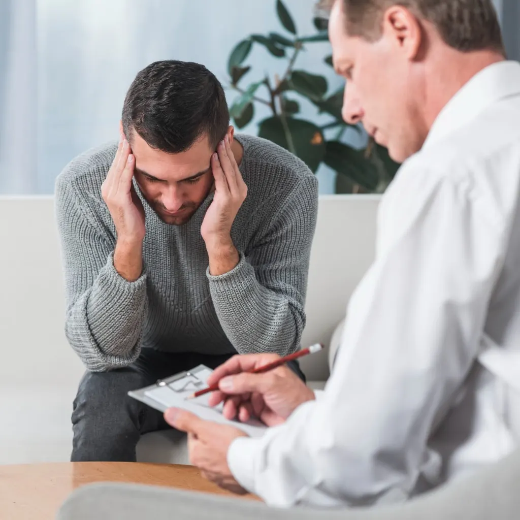 Adult in a consultation session while a clinician takes notes